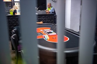 View of a poker table through bars, monitored by security personnel, Cologne police led a raid