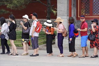 New Summer Palace, Beijing, China, Asia, Tourists in summer clothes stand in a queue next to a