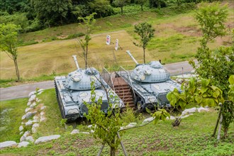 Military tanks with camouflage paint on display in public park near Nonsan, South Korea on overcast
