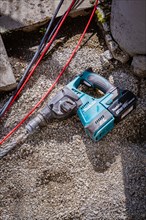 A cordless hammer drill from Makita is lying on the floor, solar systems construction, trade,