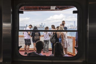 Tourists on the Staten Island ferry with a view of the Manhattan skyline, New York City, USA, New