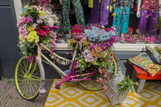 Colourful decorated bicycle in front of a fashion shop, decoration, whimsical, funny, hippie,
