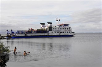 Ometepe Island, Nicaragua, A ferry with passengers sails near the shore with a mountainous
