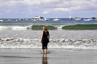 San Juan del Sur, Nicaragua, Woman on the beach looking at waves and boats, Reflections on the