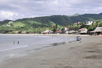 San Juan del Sur, Nicaragua, Cloudy sky over a quiet beach with green mountain landscape in the