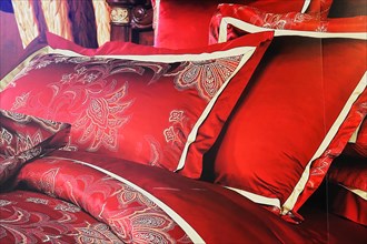 Silk factory Shanghai, Red satin cushions with golden embroidery on a bed in detail, Shanghai,