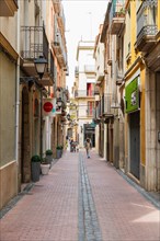 Narrow streets with shops in the city centre of Figueras, Spain, Europe
