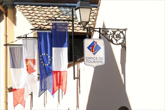 Eguisheim, Alsace, France, Europe, Flags in front of a tourist information centre cast shadows on