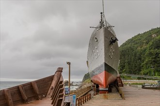 The bow of a wooden boat and exterior of South Korean battleship on display in Unification Park in