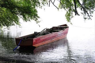 Ometepe Island, Nicaragua, Old rust-coloured rowing boat tied under hanging tree branches, Central