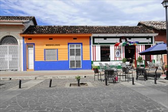 Granada, Nicaragua, Colourful facades of buildings along a quiet, cobbled street, Central America,