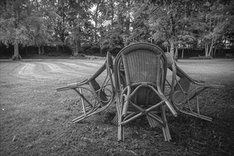 Four chairs are grouped around a table under a tree in a park, St George's Monastery, Isny im