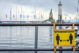 Advertising sign for physical distancing on the harbour railing in the old town of Lindau (Lake