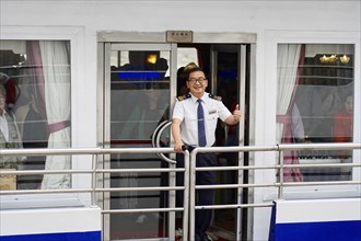 Chongqing, Chongqing Province, China, A ship officer in uniform smiles and greets friendly from a