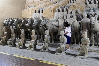 Figures of the terracotta army, Xian, Shaanxi Province, China, Asia, Visitor looking at the