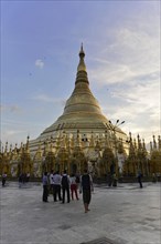 Shwedagon Pagoda, Yangon, Myanmar, Asia, Pilgrims walk around a large, illuminated stupa, Asia