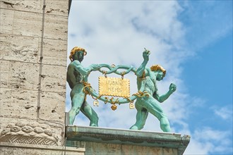 Golden biscuit with the 2 facade figures of the pretzel men on the Art Nouveau facade of the