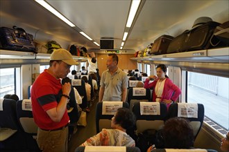 Express train CRH380 to Yichang, passengers standing and sitting in an illuminated train interior,
