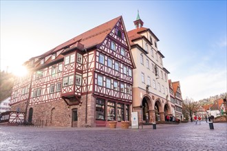 Sunset over a characteristic half-timbered building on a quiet town square, town hall, spring,