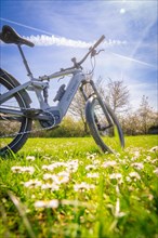 A bicycle leaning on a blooming meadow in the bright sunshine, spring, E- Bike Waldbike, Gechingen,