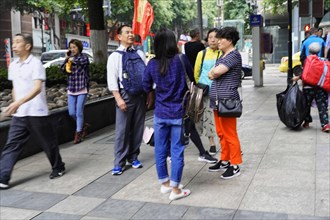 Chongqing, Chongqing Province, China, Asia, Several people stand together in a group and talk on
