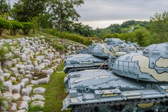 Closeup of gun turret on military tanks with camouflage paint on display in public park in Nonsan,