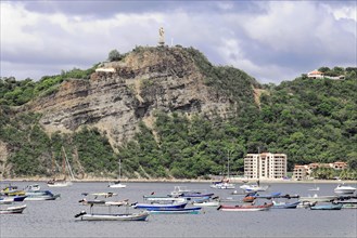 San Juan del Sur, Nicaragua, A statue of Jesus is enthroned on a wooded hill above a bay with