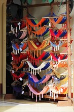 Granada, Nicaragua, Colourful hammocks displayed in front of a shop, hung on a large wooden frame,