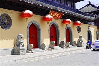 Jade Buddha Temple, Shanghai, A row of red lanterns and stone sculptures in front of a temple,