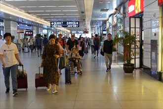Hongqiao railway station, Shanghai, China, Asia, travellers with wheeled luggage in a well-lit
