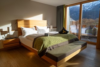 Modern furnished bedroom with large window and view of the mountains, Bad Reichenhall, Bavaria,