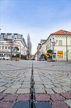 View along the cobbled town street with rows of shops and lanterns, Bad Reichenhall, Bavaria,