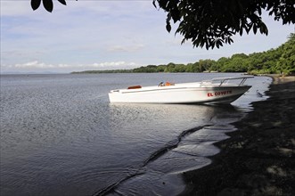 Ometepe Island, Nicaragua, White motorboat on calm shore with cloudy sky in the background, Central