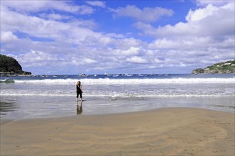 San Juan del Sur, Nicaragua, A person stands on a sandy beach, looking at the sea and the horizon,