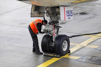 AUGUSTO C. SANDINO Airport, Managua, Nicaragua, An airport employee checks the landing gear of an