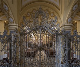 Artistic, wrought-iron gate in front of the interior of Ebrach Abbey, former Cistercian abbey,