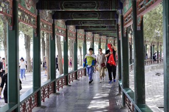 New Summer Palace, Beijing, China, Asia, Tourists walk through a historic corridor with elaborate
