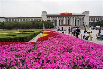 Beijing, China, Asia, Blooming flower beds in front of a large historic building in a busy city,