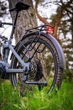Detailed view of the rear part of an e-bike with focus on the rear light and the tyre, spring,