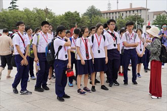 Beijing, China, Asia, school class in uniforms with medals listens to a guide during a city tour,