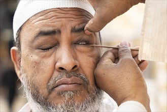 GUWAHATI, INDIA, APRIL 11: A Muslim man applies Surma on eyes during Eid Al-Fitr in Guwahati, India