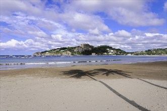 San Juan del Sur, Nicaragua, Wide beach with the shade of palm trees, rock formations in the