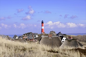 Lighthouse, Hoernum, Sylt, North Frisian Island, lighthouse rises behind a settlement with thatched