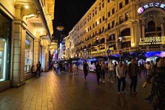 Evening stroll through Shanghai to the sights, Shanghai, on a busy street with shops and