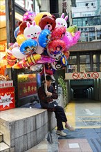 Chongqing, Chongqing Province, China, Asia, A street vendor sits on a wall and sells colourful