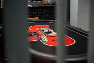 A red poker table with chips and cards, focussed and detailed, Cologne police led a raid against