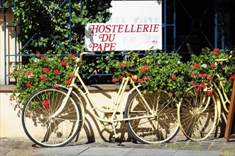 Eguisheim, Alsace, France, Europe, Yellow bicycle with flower decoration in front of 'Hostellerie