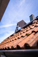 A labourer works on a tiled roof, solar systems construction, craft, Muehlacker, Enzkreis, Germany,