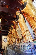 Jade Buddha Temple, Shanghai, group of carved Buddha statues and wall relief in wood-panelled