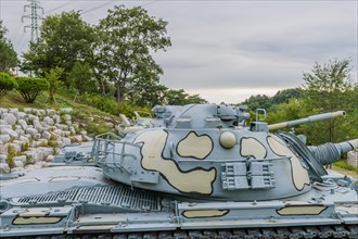 Closeup of gun turret on military tank with camouflage paint on display in public park in Nonsan,